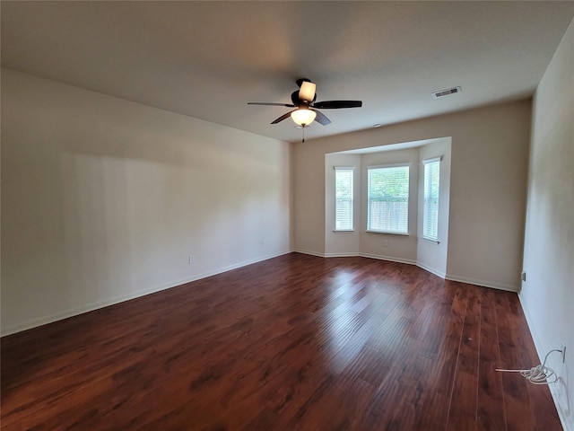 empty room featuring ceiling fan and dark wood-type flooring