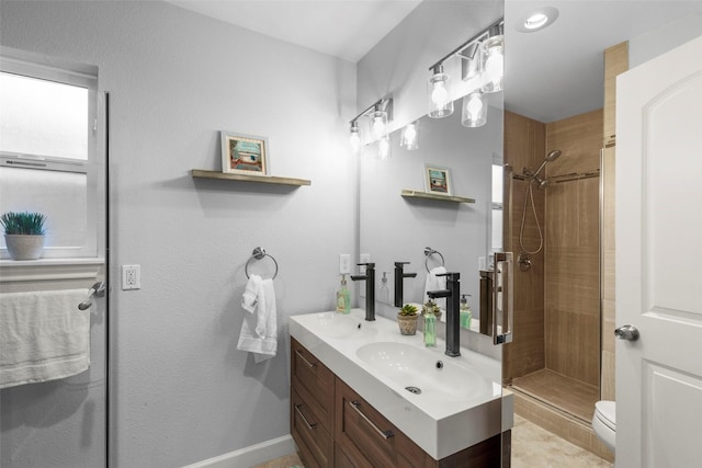 bathroom featuring vanity, toilet, and a tile shower