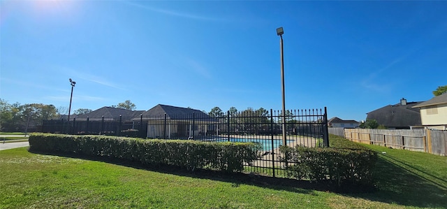 view of swimming pool with a yard