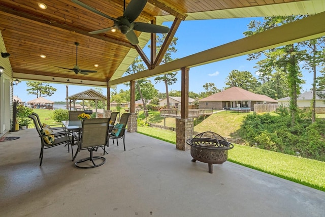 view of patio featuring a gazebo, ceiling fan, and an outdoor fire pit