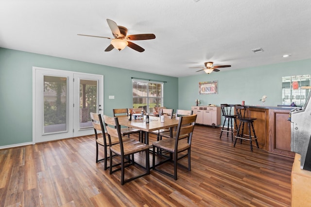 dining room featuring a textured ceiling, dark hardwood / wood-style floors, and ceiling fan