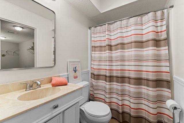 bathroom featuring vanity, a textured ceiling, and toilet