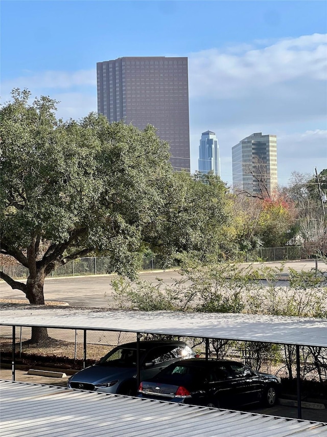 covered parking lot with a view of city and fence