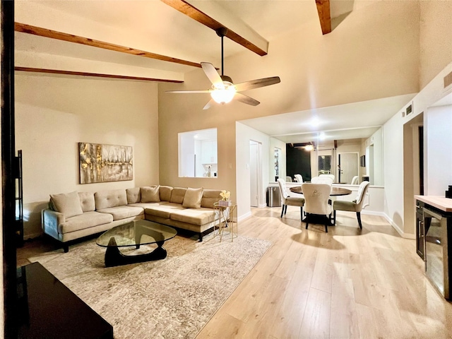 living room featuring beam ceiling, ceiling fan, light wood-type flooring, and high vaulted ceiling