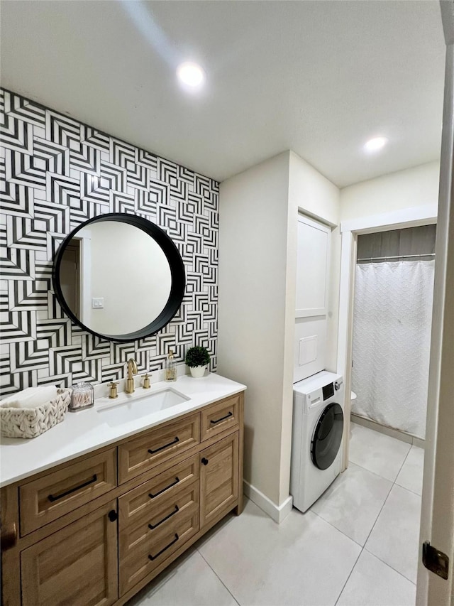 bathroom featuring tile patterned flooring, washer / clothes dryer, toilet, vanity, and backsplash