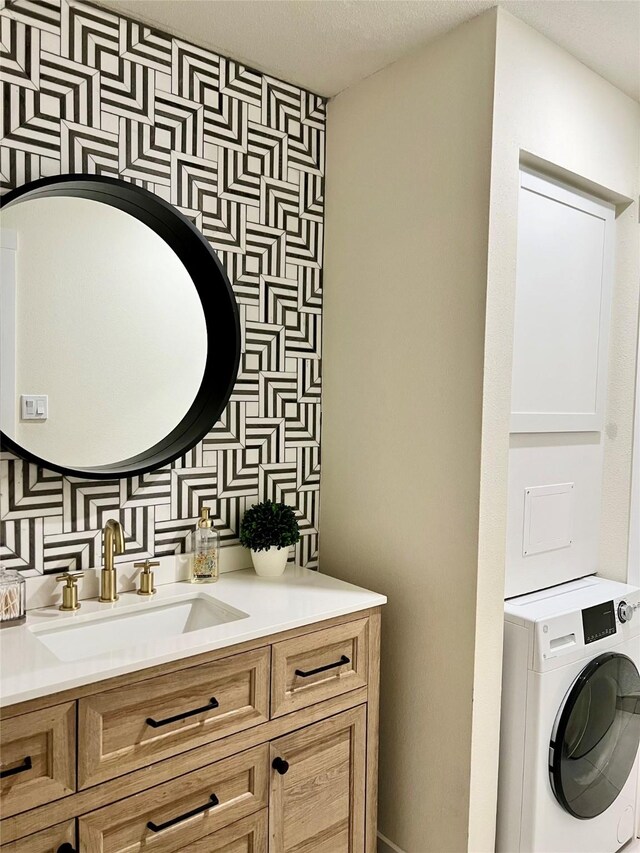 bathroom featuring washer / clothes dryer, tasteful backsplash, and vanity