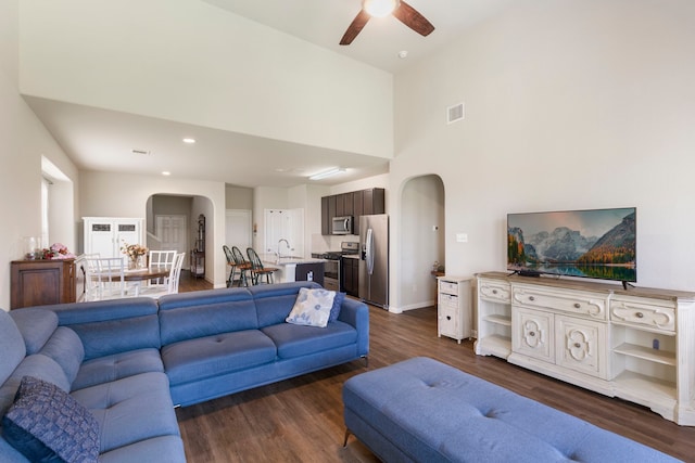 living room with dark hardwood / wood-style flooring, ceiling fan, and sink