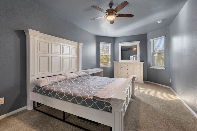 carpeted bedroom with multiple windows and ceiling fan