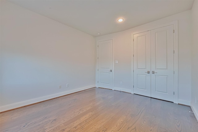 unfurnished bedroom featuring light hardwood / wood-style floors and a closet