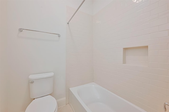 bathroom featuring tiled shower / bath and toilet