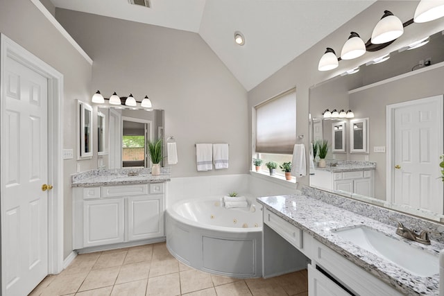 bathroom featuring a bathing tub, vanity, tile patterned floors, and lofted ceiling