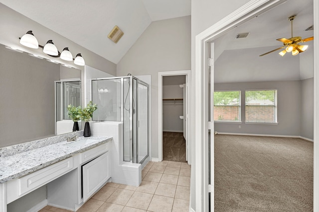 bathroom with tile patterned floors, vanity, a shower with shower door, and lofted ceiling