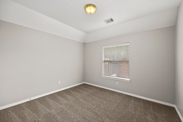 carpeted empty room featuring lofted ceiling