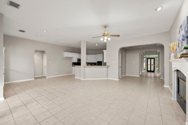 unfurnished living room with light tile patterned floors and ceiling fan