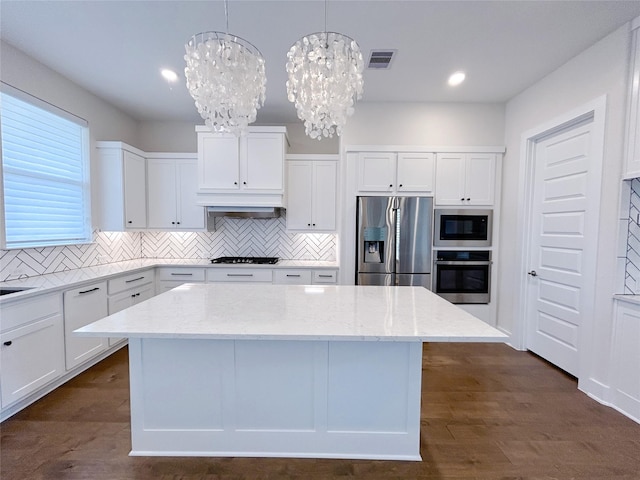 kitchen featuring pendant lighting, white cabinetry, appliances with stainless steel finishes, and an inviting chandelier