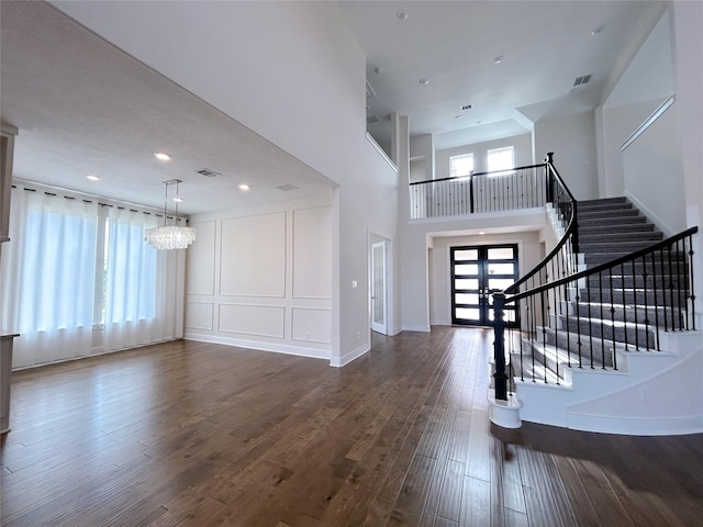 foyer entrance featuring hardwood / wood-style flooring, a healthy amount of sunlight, and a notable chandelier