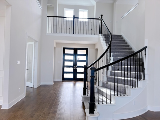 entrance foyer with french doors, dark hardwood / wood-style floors, and a high ceiling