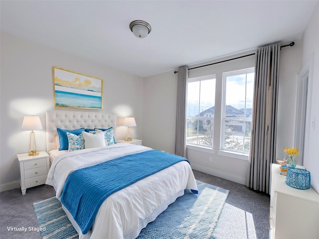 bedroom featuring dark carpet and multiple windows