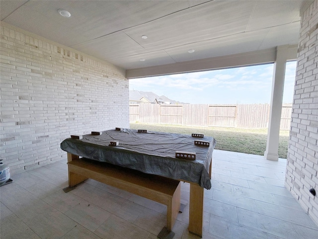 exterior space with plenty of natural light, brick wall, and pool table