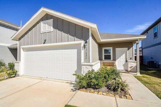 view of front of home with central AC unit and a garage