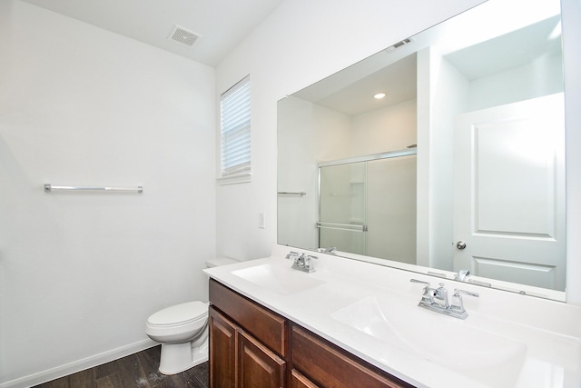 bathroom featuring vanity, wood-type flooring, toilet, and walk in shower