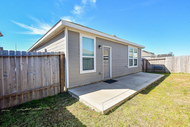 rear view of house with a patio and a lawn