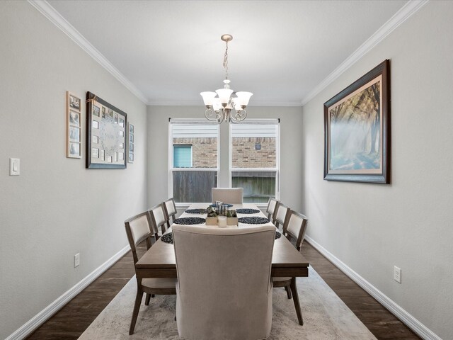 dining area featuring dark hardwood / wood-style flooring, ornamental molding, and an inviting chandelier