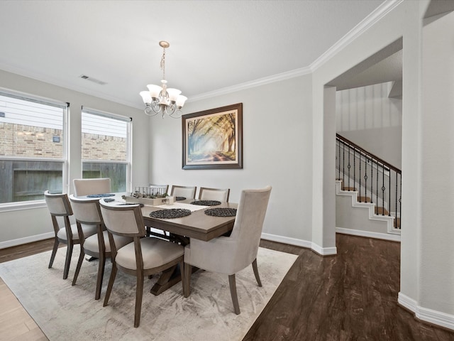 dining area featuring crown molding, dark hardwood / wood-style flooring, and a chandelier