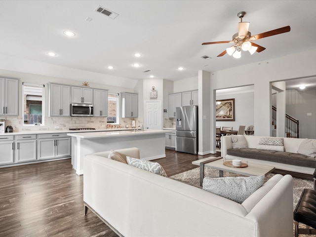 living room with ceiling fan, dark hardwood / wood-style floors, and sink