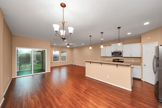 kitchen with white cabinets, pendant lighting, a breakfast bar area, and appliances with stainless steel finishes