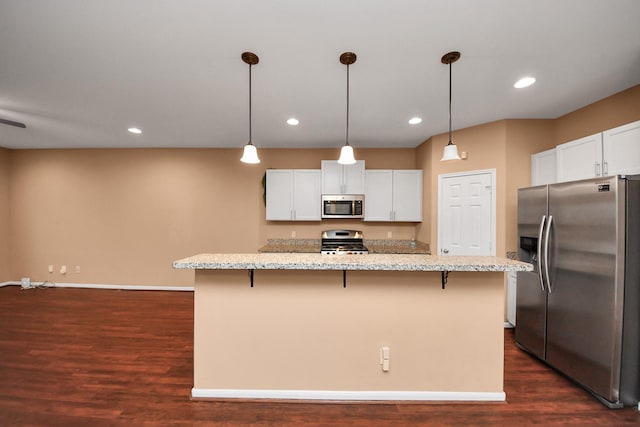 kitchen featuring white cabinetry, a kitchen island, hanging light fixtures, and appliances with stainless steel finishes