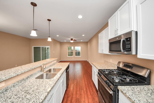 kitchen featuring white cabinets, decorative light fixtures, and stainless steel appliances