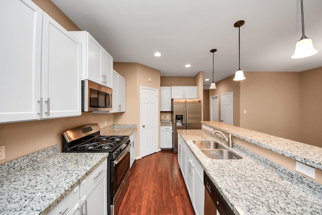 kitchen with white cabinets, hanging light fixtures, sink, and appliances with stainless steel finishes