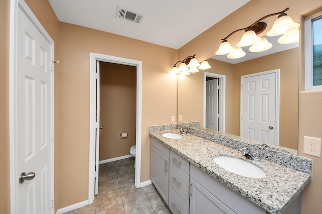 bathroom featuring tile patterned flooring, vanity, and toilet