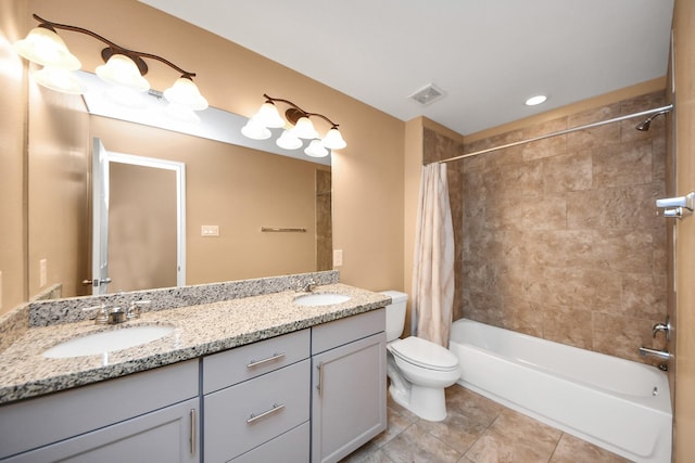 full bathroom featuring tile patterned flooring, shower / bath combo with shower curtain, vanity, and toilet