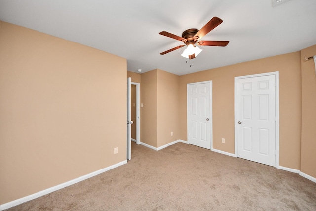 unfurnished bedroom featuring light carpet and ceiling fan