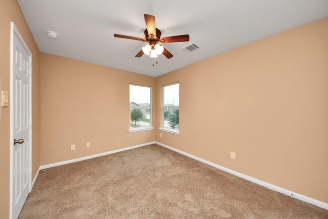 spare room featuring light carpet and ceiling fan