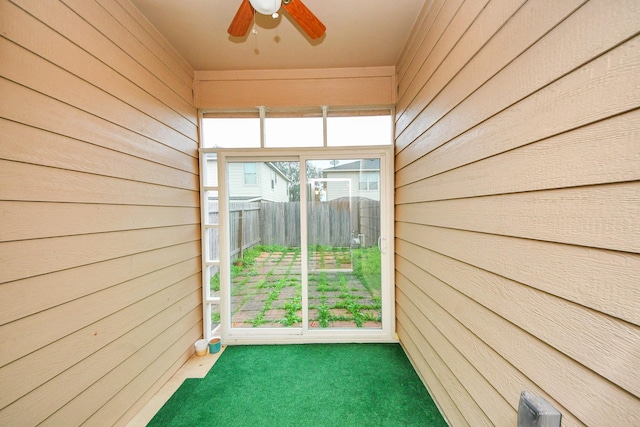 unfurnished sunroom featuring ceiling fan