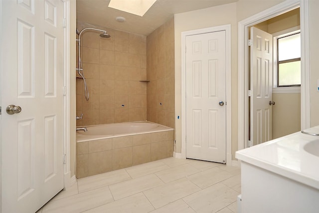 bathroom with tile patterned flooring, tiled shower / bath combo, and a skylight