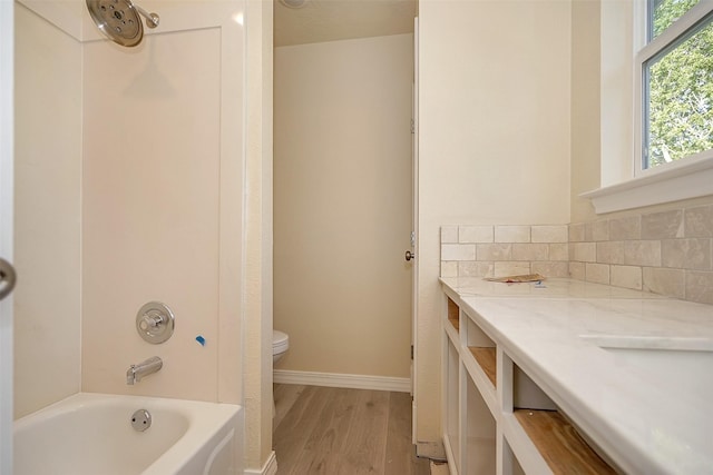 full bathroom featuring decorative backsplash, vanity,  shower combination, wood-type flooring, and toilet