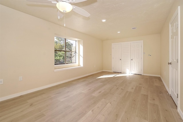 unfurnished bedroom with ceiling fan, light wood-type flooring, and a closet