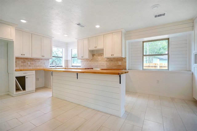 kitchen with sink, white cabinets, and wood counters