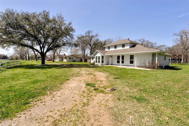 rear view of property with a yard and fence