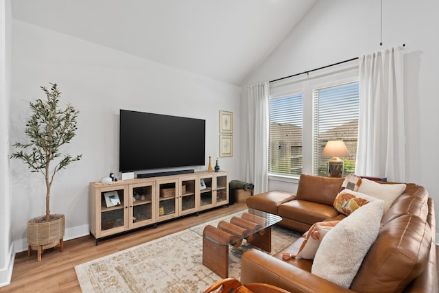 living room featuring high vaulted ceiling and light wood-type flooring