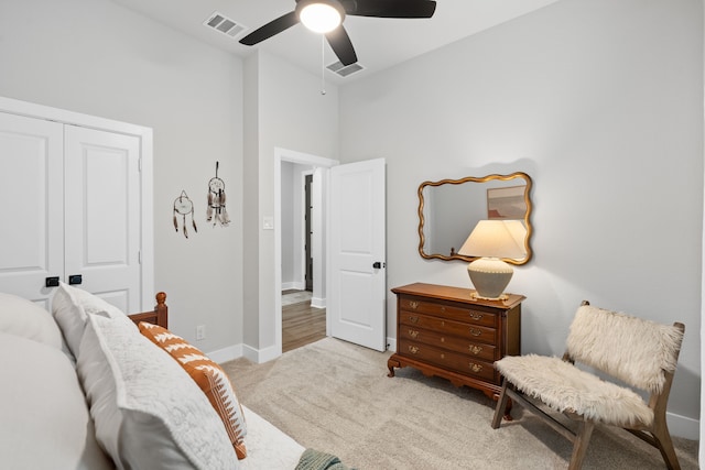 living area featuring light colored carpet and ceiling fan