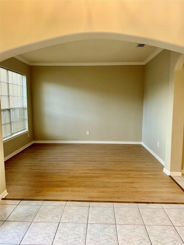 tiled spare room with crown molding