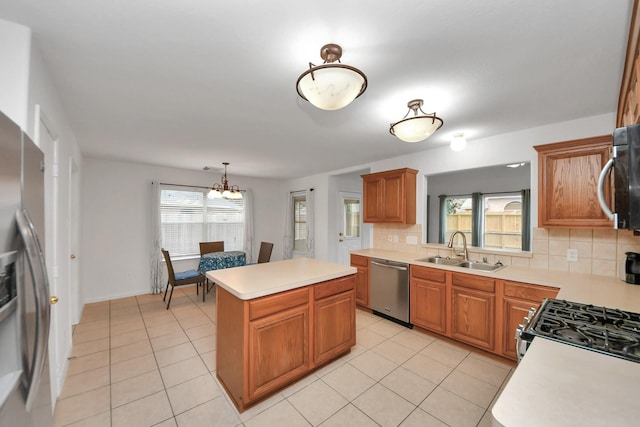 kitchen with a kitchen island, tasteful backsplash, sink, a chandelier, and stainless steel appliances