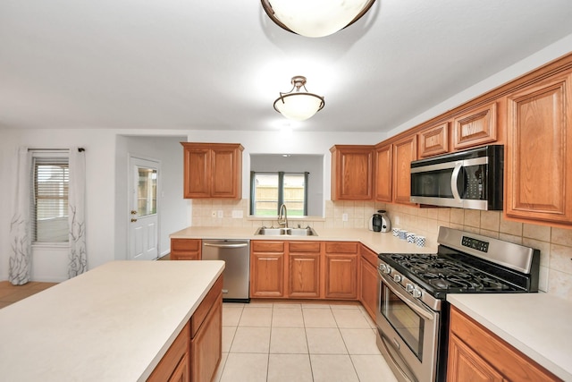 kitchen with a healthy amount of sunlight, stainless steel appliances, sink, and decorative backsplash