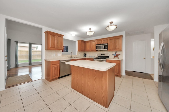 kitchen featuring light tile patterned flooring, sink, a center island, stainless steel appliances, and backsplash