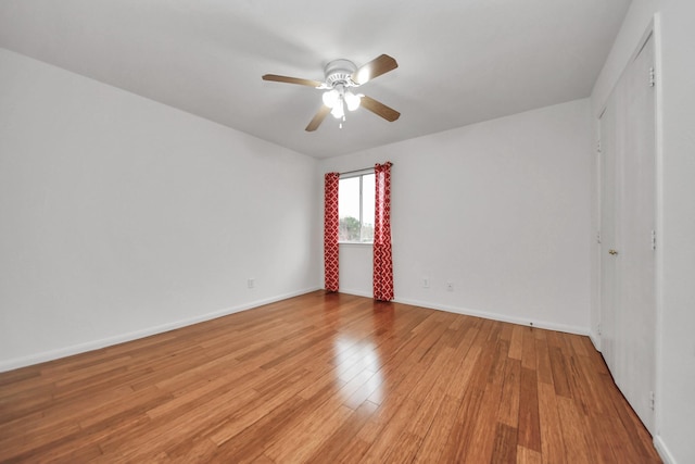 empty room with ceiling fan and light hardwood / wood-style flooring